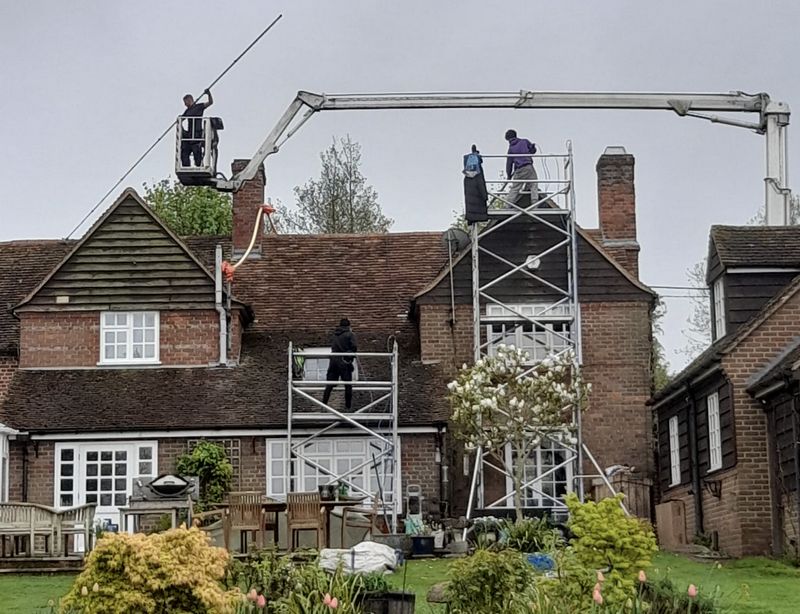 The Roof Moss Cleaners using cherry picker and scaffolding to clean roof safely and professionally in Chertsey, Surrey